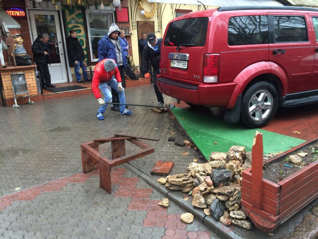 Чиновники выковыривают летнюю площадку кафе из-под авто. Фото