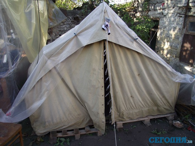 Семья, потерявшая в пожаре жилье, разбила на пепелище палатку и готовится зимовать. Фото